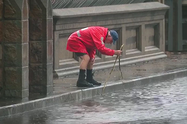 What a legend! Elderly man takes it upon himself to help motorists stranded by Sydney flooding